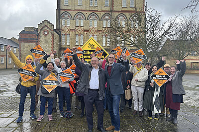 Ian Sollom, Ed Davey and lots of Lib Dems holding diamonds in front of Paines Mill at Phoenix Square
